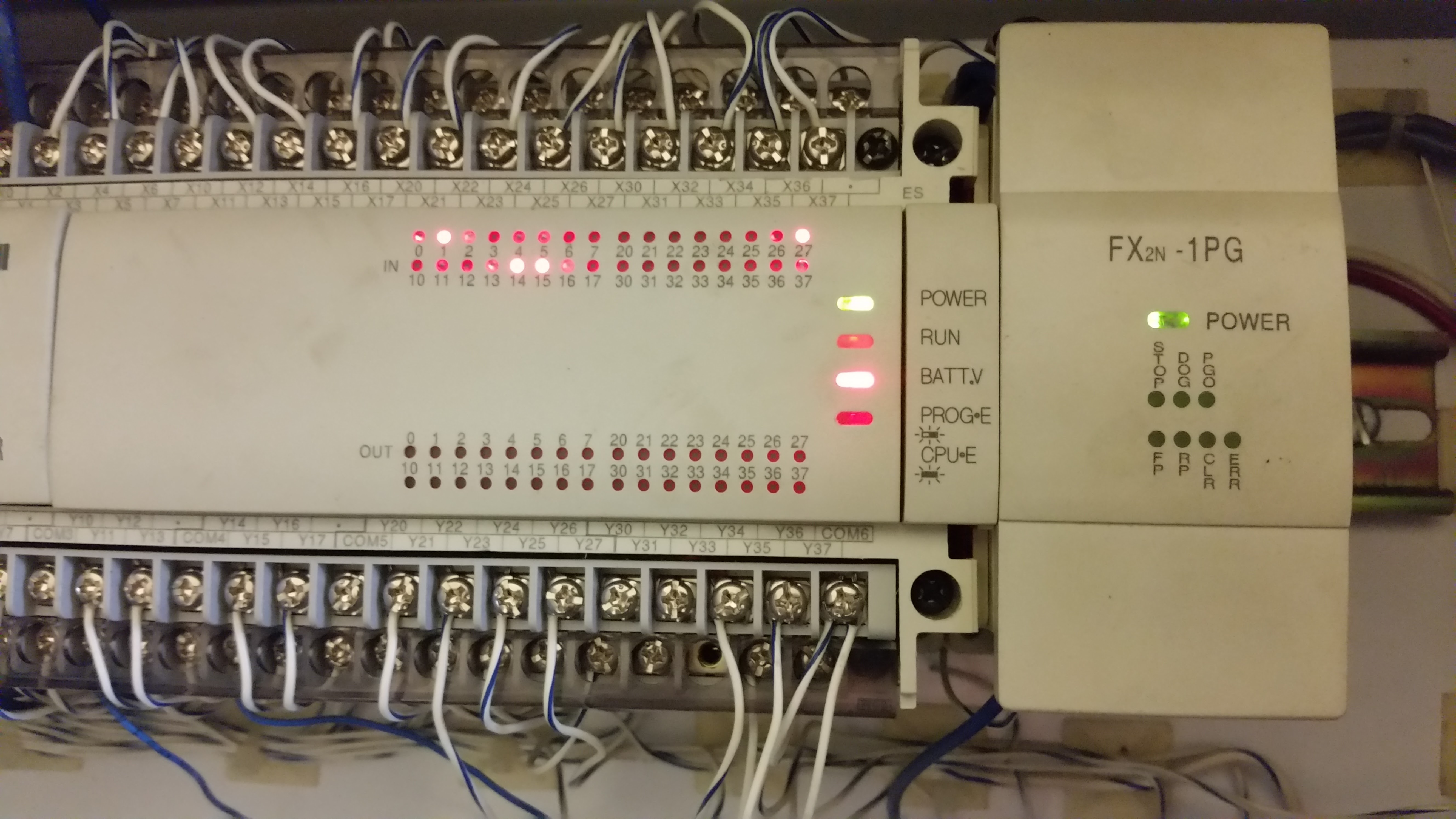 Mitsubishi PLC hardware with active I/O status lights during troubleshooting